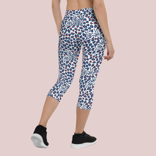 Person wearing a patterned capri leggings on a white background