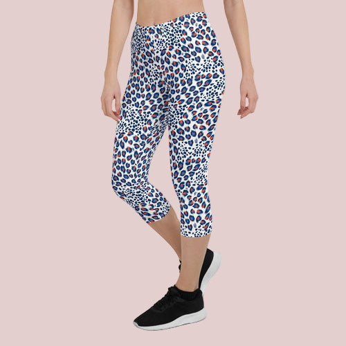 Person wearing a patterned capri leggings on a white background