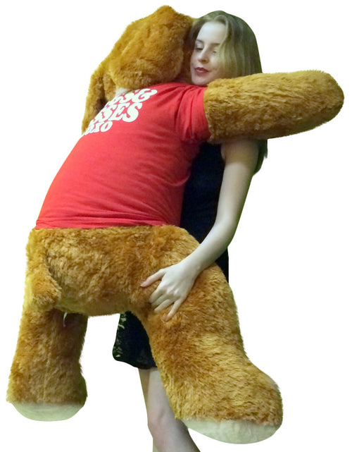 Person hugging a large brown teddy bear with a white shirt on a white background