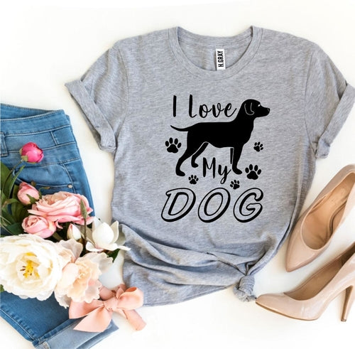 Gray t-shirt with 'I Love My Dog' graphic on a white background with jeans, shoes, and flowers.