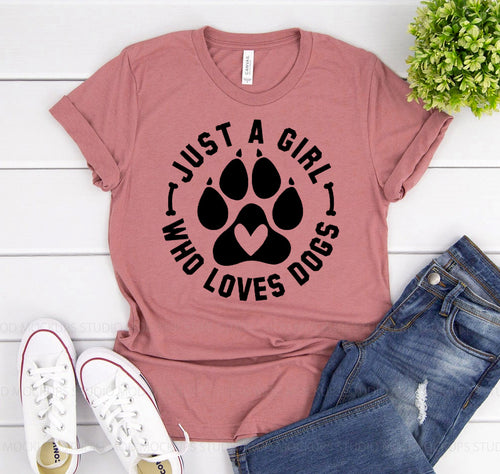 Pink t-shirt with paw print design and text, paired with jeans and sneakers on a white surface.