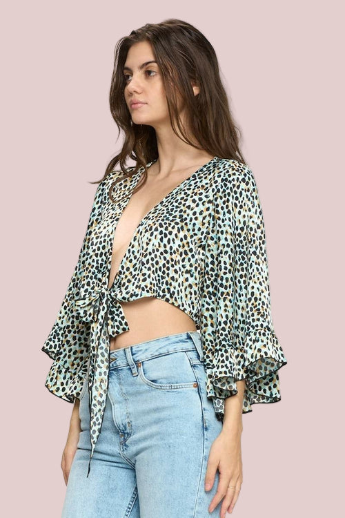 Woman wearing a leopard print top and blue jeans on a white background