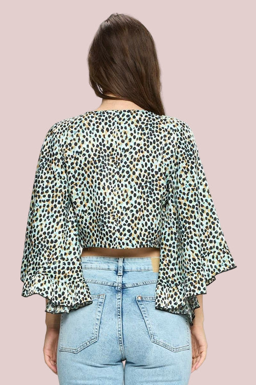 Person wearing a leopard print top and light blue jeans on a white background
