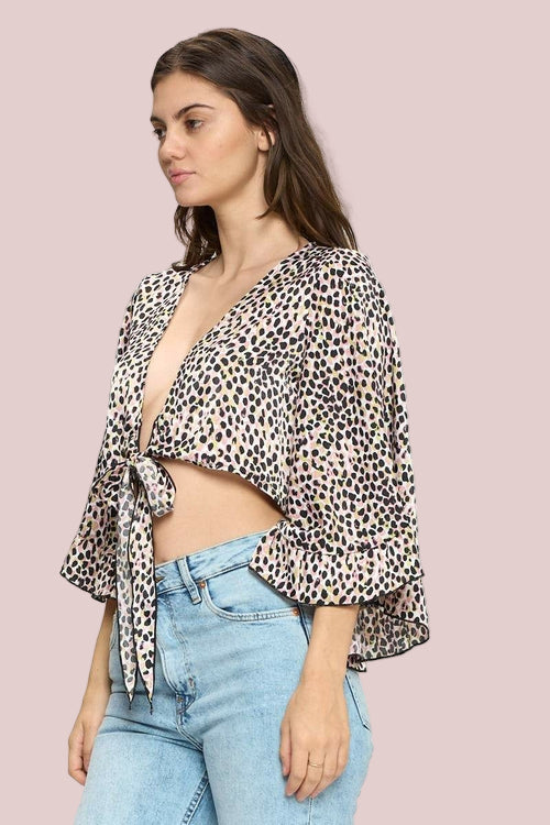 Woman wearing a leopard print top and light blue jeans on a white background