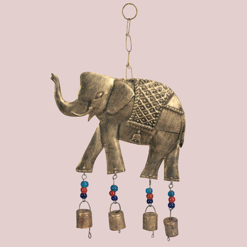 Decorative brass elephant with hanging bells on a white background