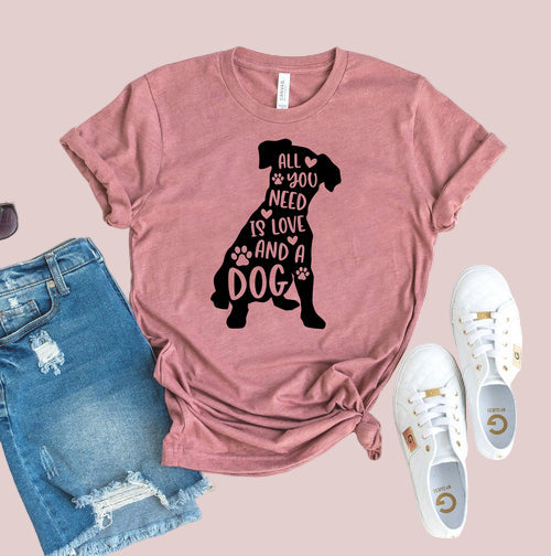 Pink t-shirt with dog graphic and text, paired with denim shorts and white sneakers on a white background