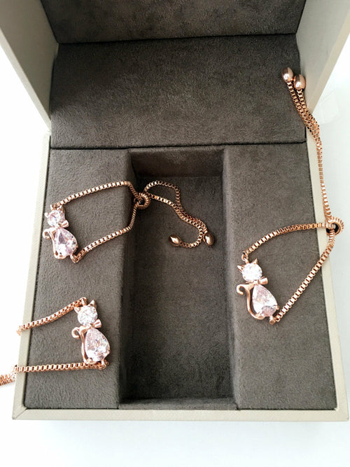 Rose gold jewelry set with cat-shaped pendants in a gray box